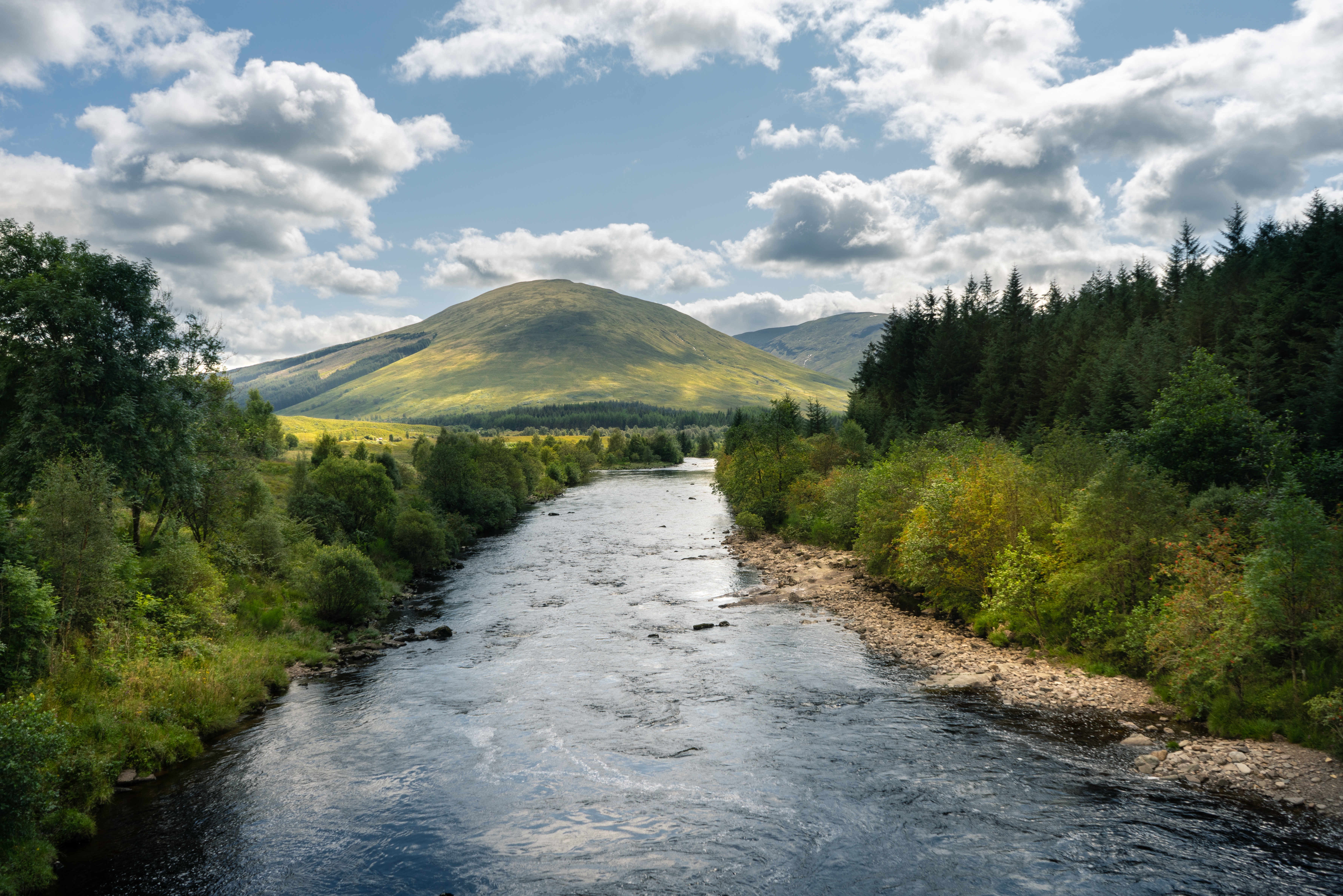 Голубое небо с белыми облаками над горной рекой