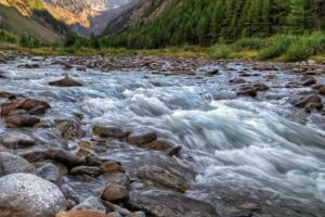 Горная река с холодной водой и каменистым руслом