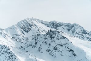 Горная снежная вершина под серыми тучами