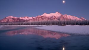 Лунное отражение в замерзшем озере у снежных гор