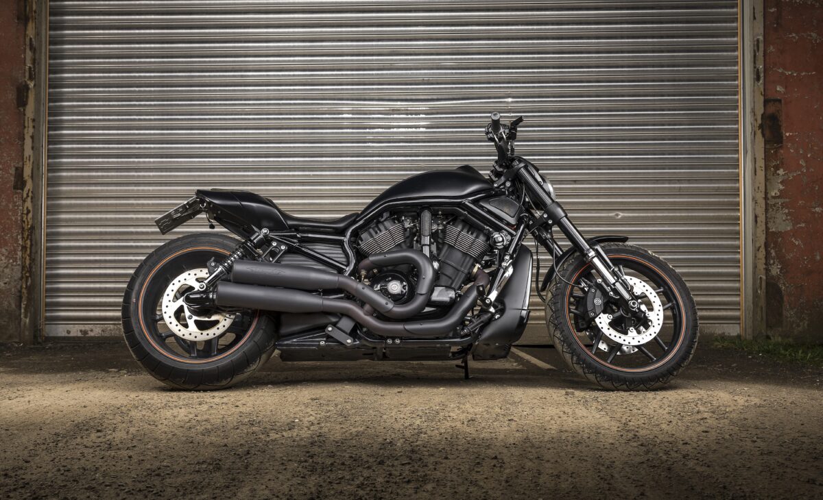 Мототехника черный тяжелый мотоцикл Harley Davidson у гаража
