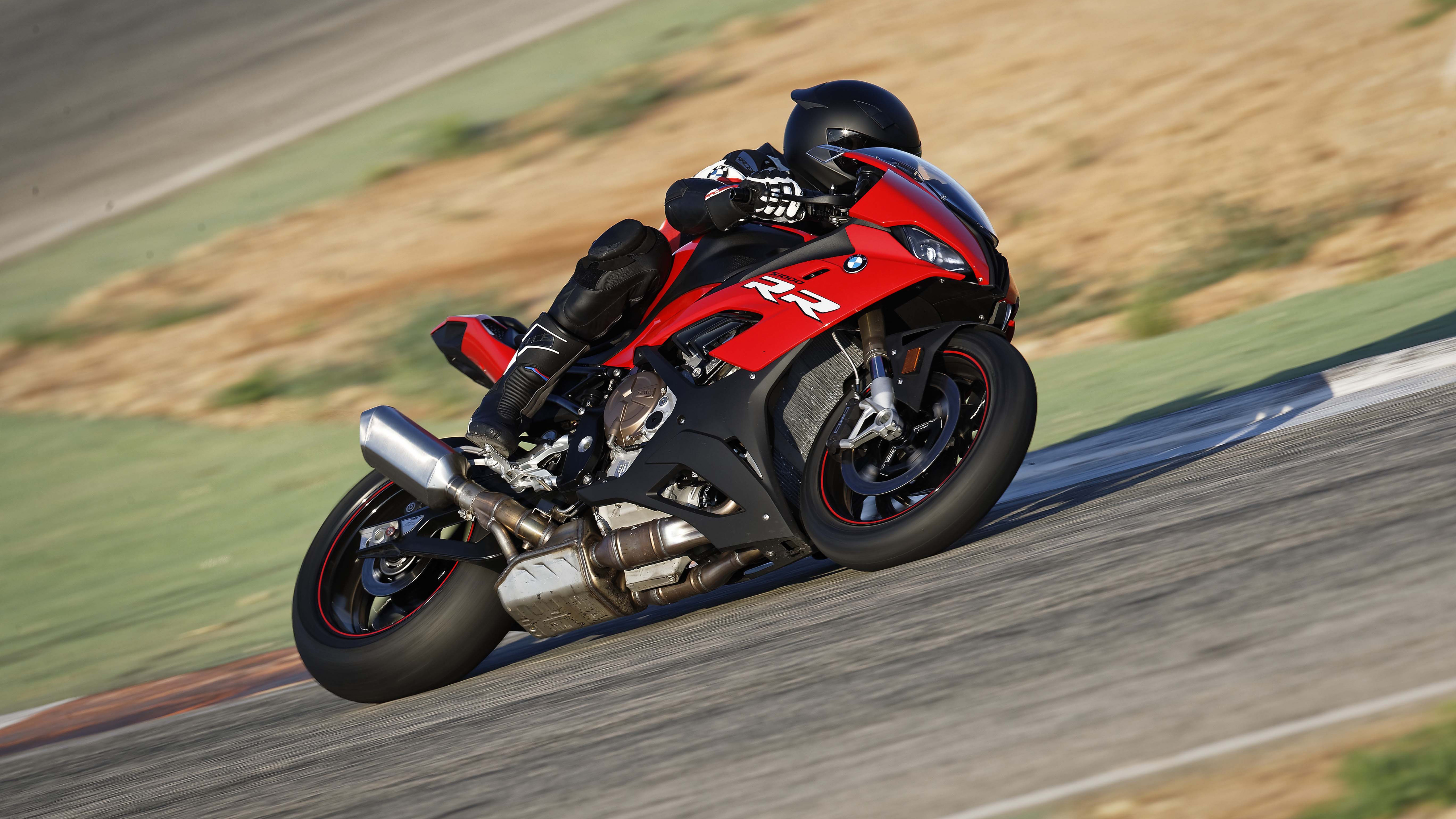 Мототехника гонщик на мотоцикле BMW S1000 совершает крутой поворот