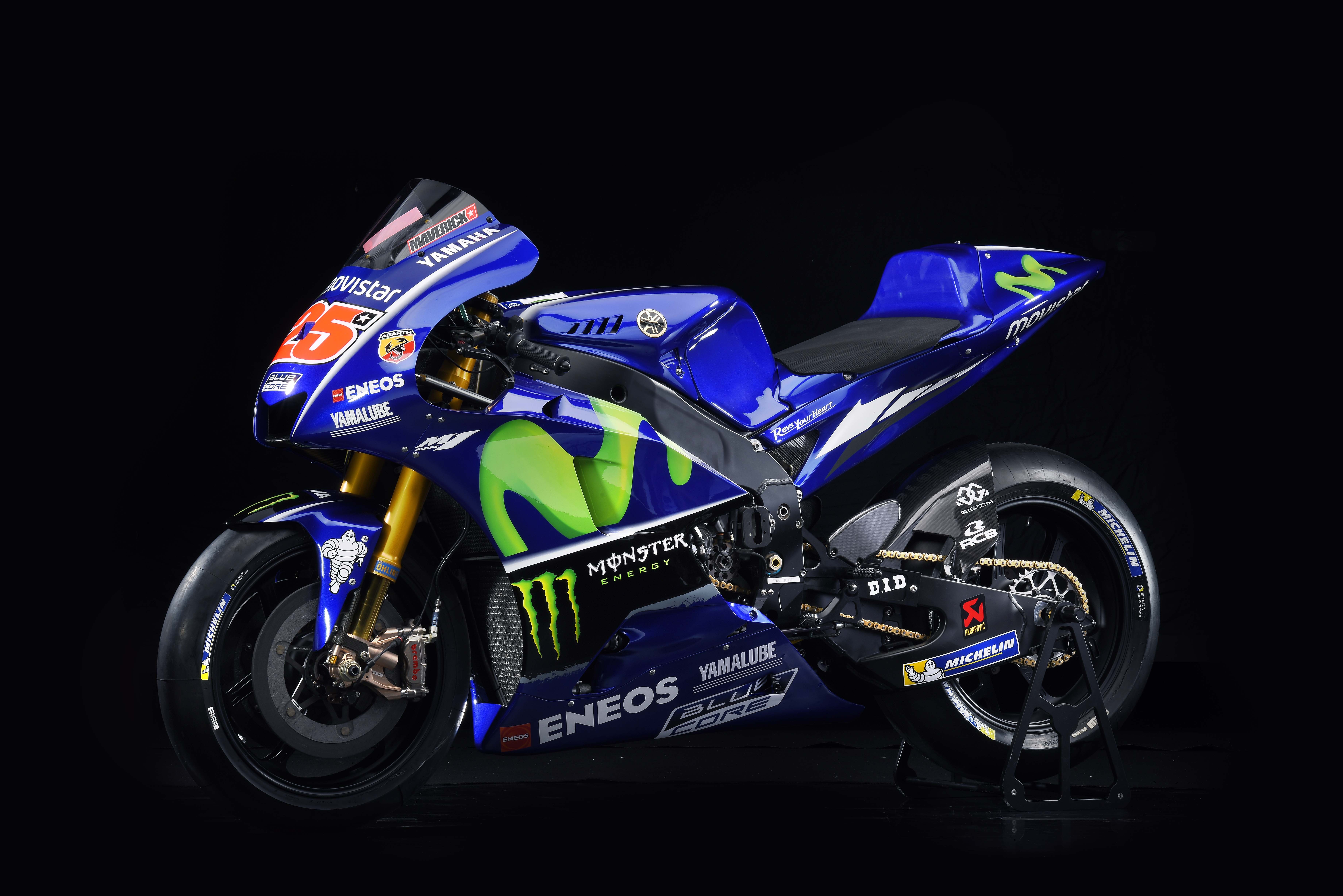 На черном фоне мотоцикл Yamaha YZR M1