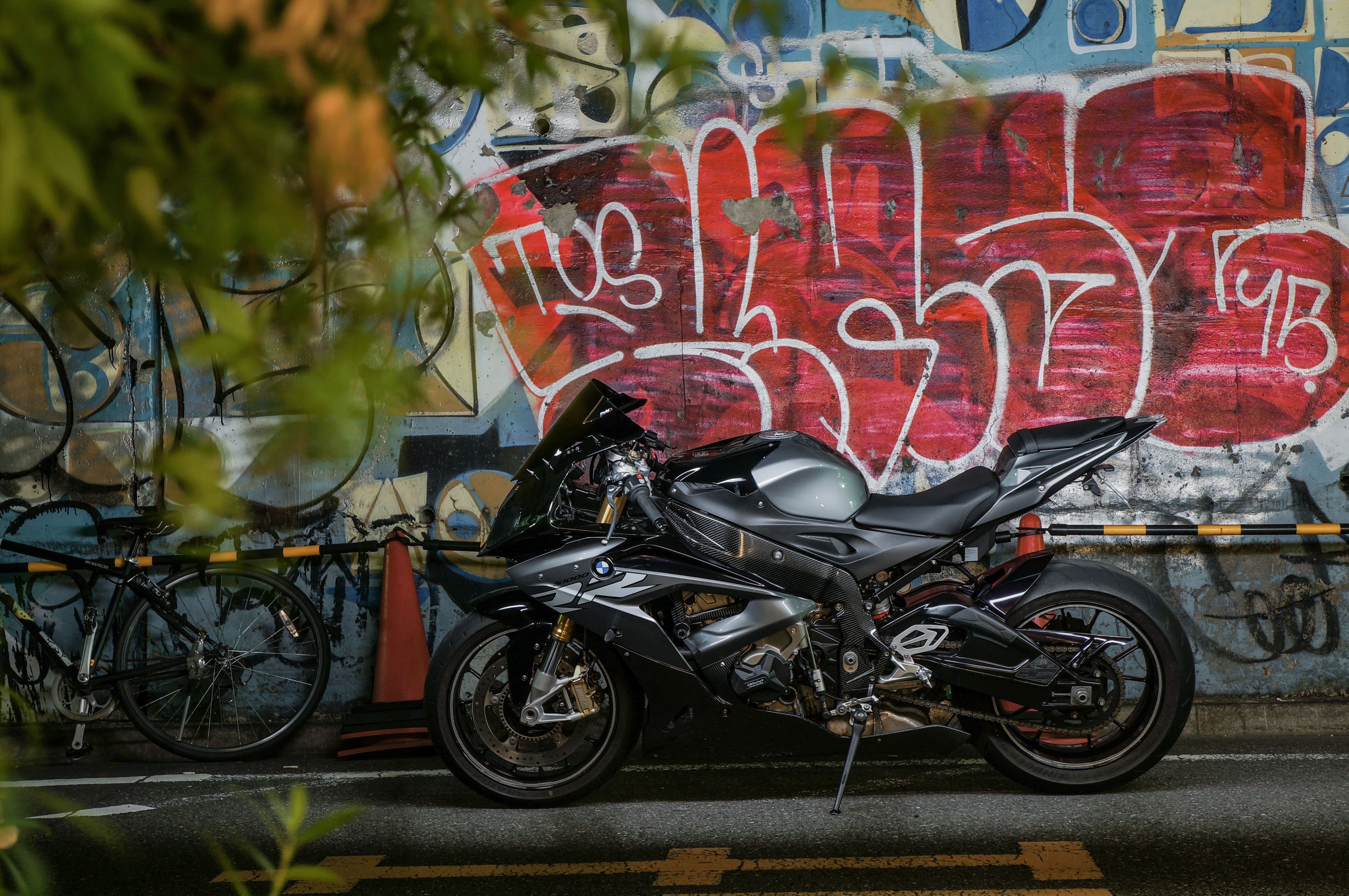 На фоне разрисованной стены черный мотоцикл BMW S1000RR