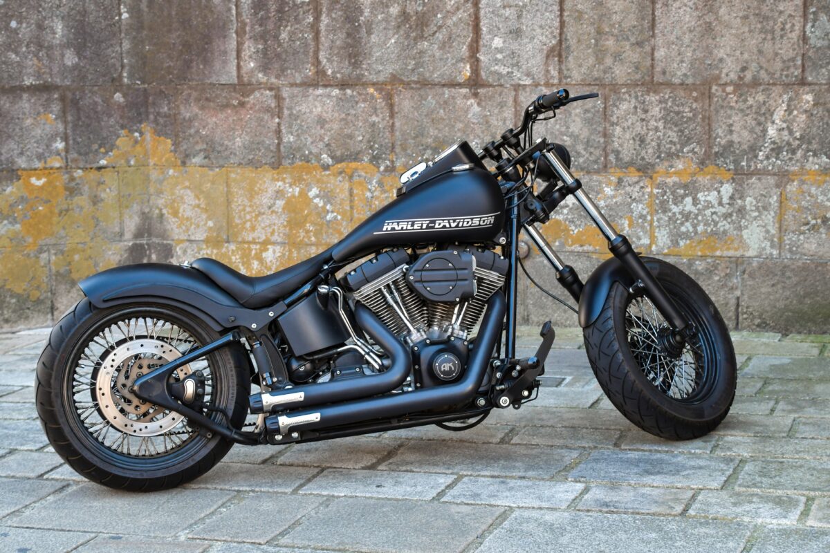 На фоне стены черный стильный мотоцикл Harley Davidson