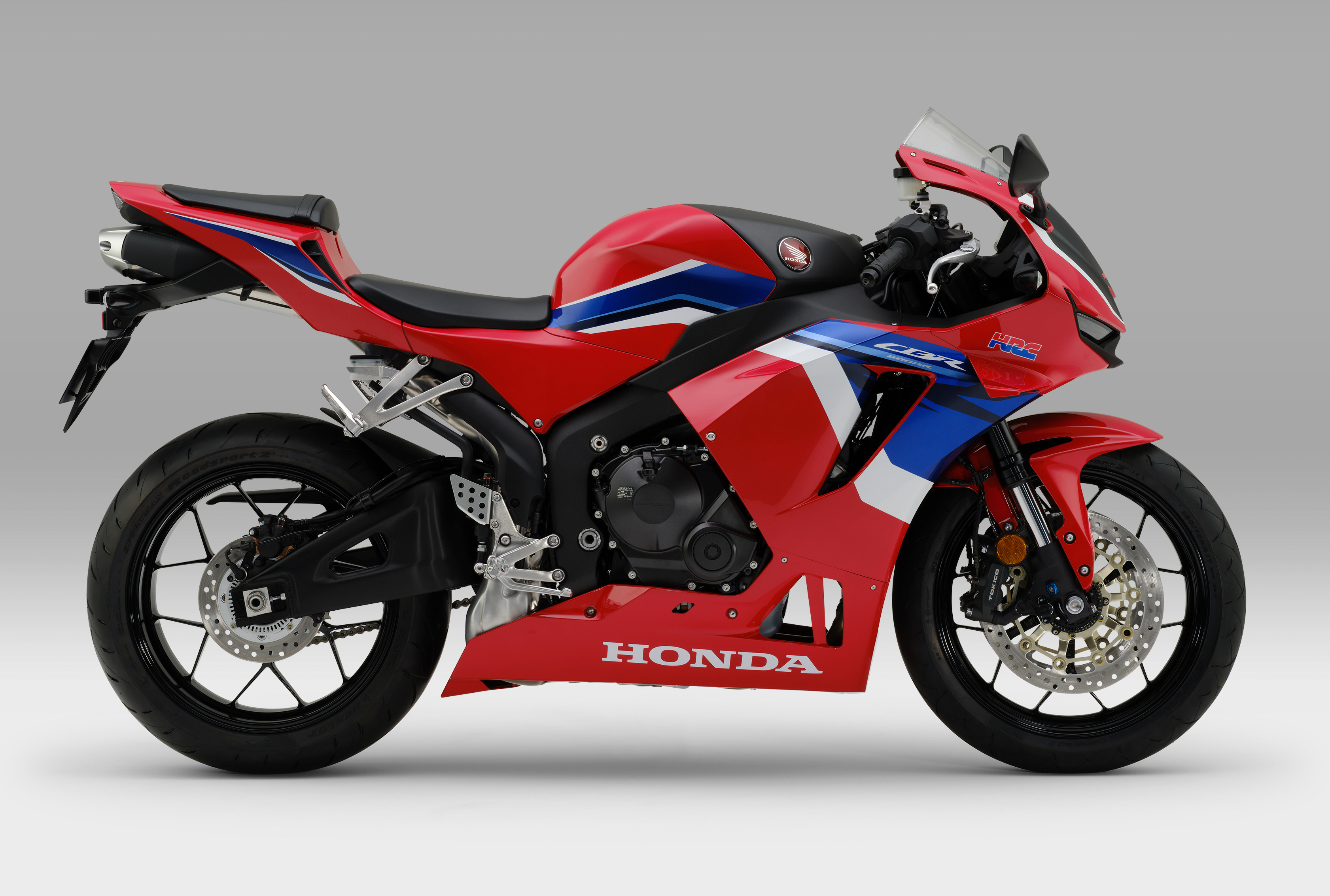 На сером фоне красный мотоцикл Honda cbr600rr 2021