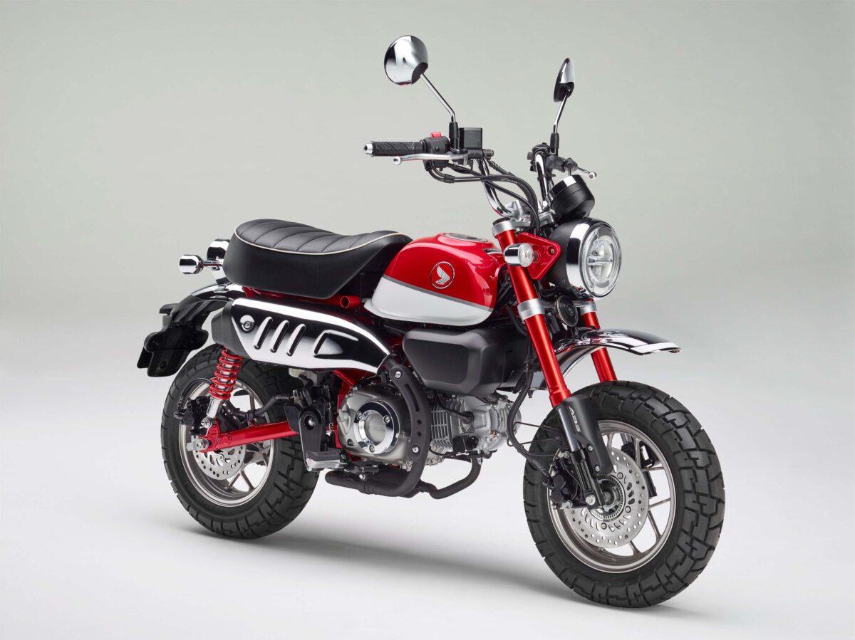 На сером фоне красный мотоцикл Honda Monkey, 2018 года