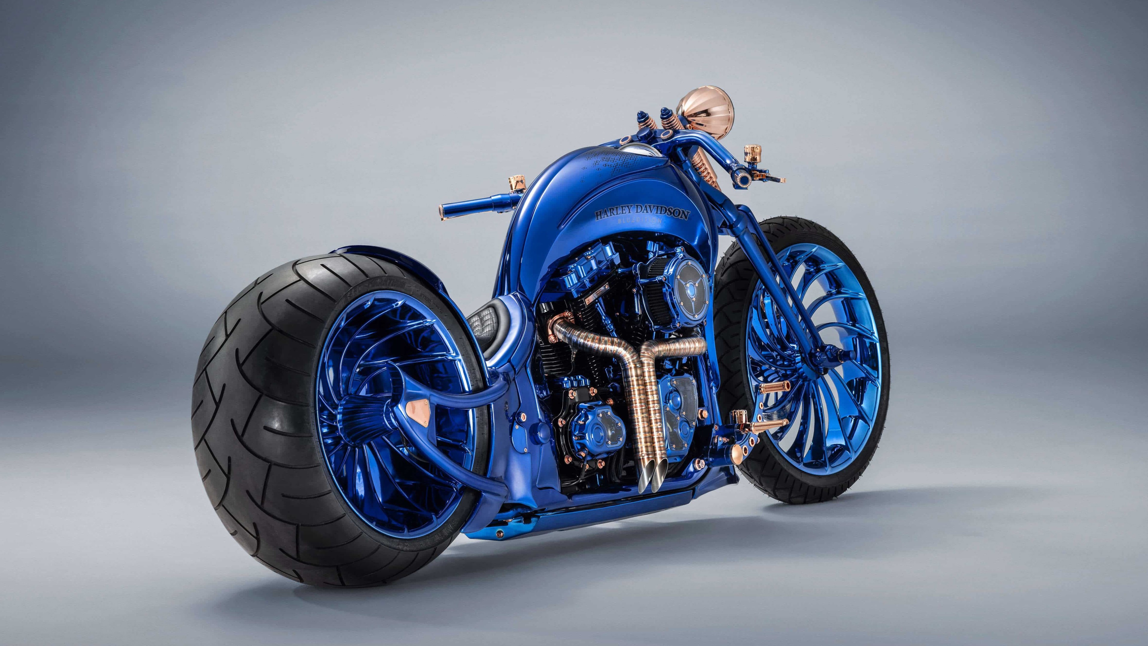 На сером фоне синий дорогой мотоцикл Harley Davidson