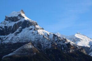 Залитая солнцем снежная вершина горы